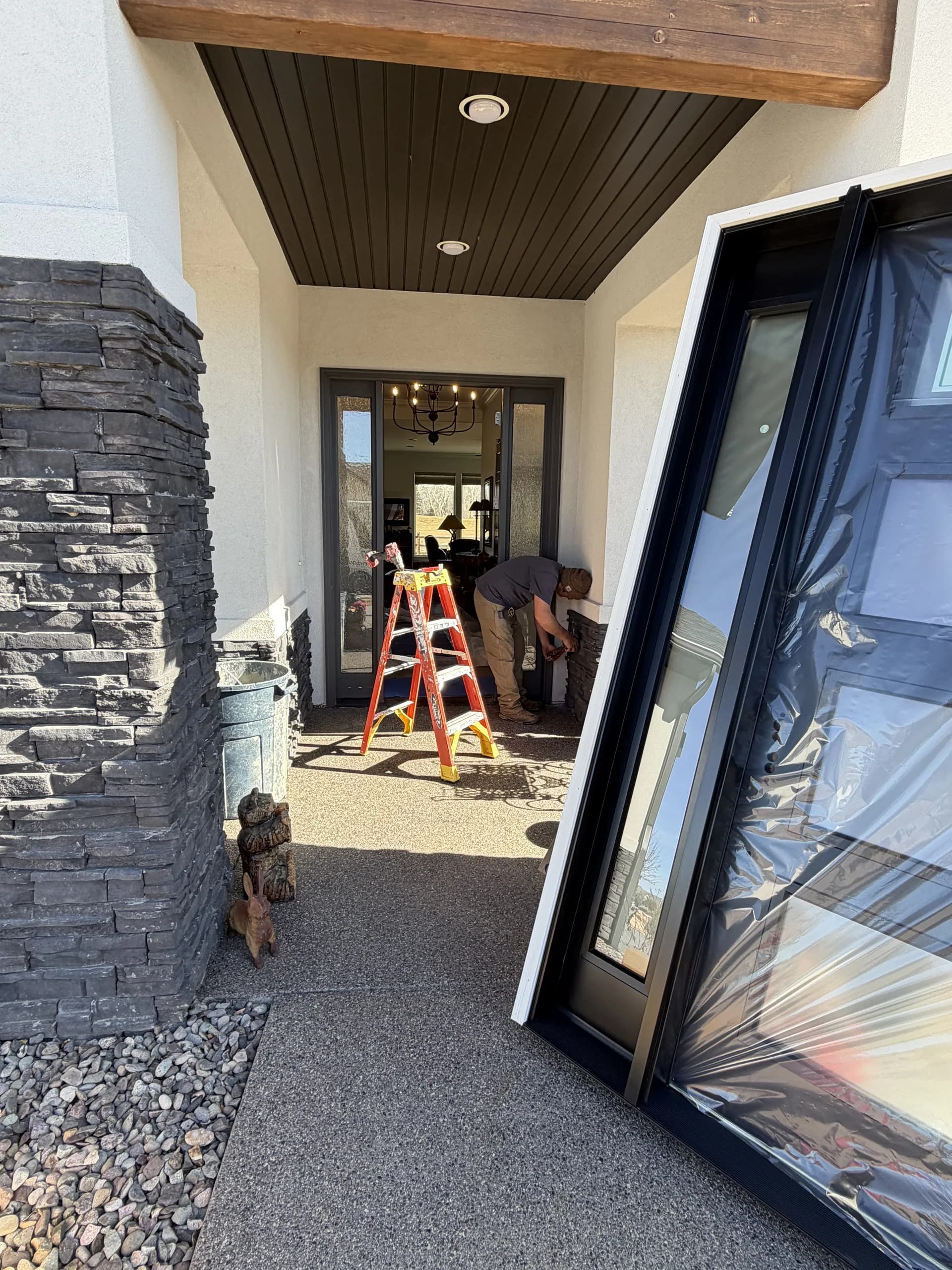 Modern black multi-panel glass doors installed opening to mountain view patio